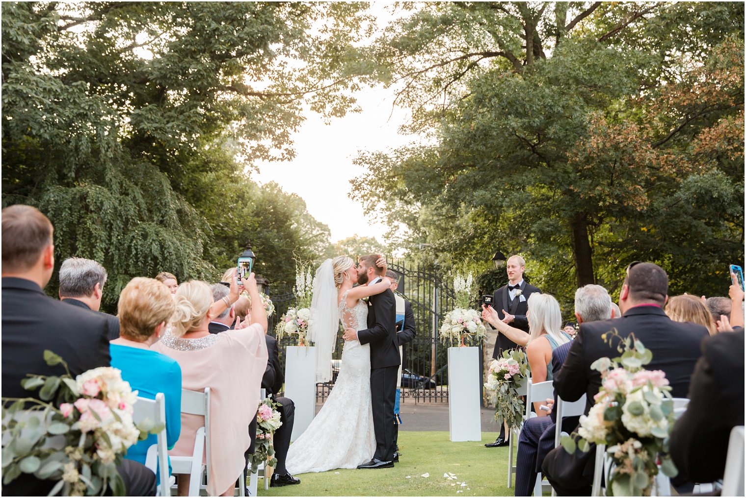 first kiss as newlyweds during Huntingdon Valley Country Club wedding ceremony photographed by Idalia Photography