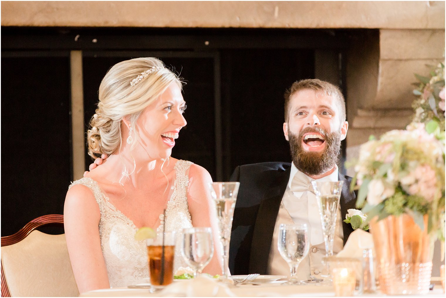 bride and groom laugh during wedding toasts photographed by Idalia Photography