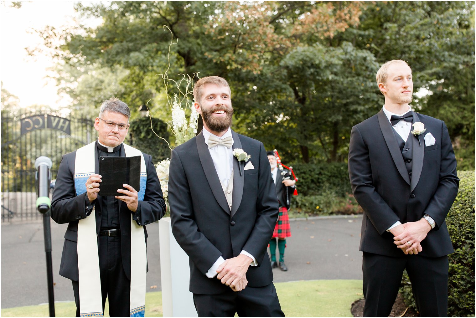 groom watches bride during wedding ceremony at Huntingdon Valley Country Club photographed by Idalia Photography