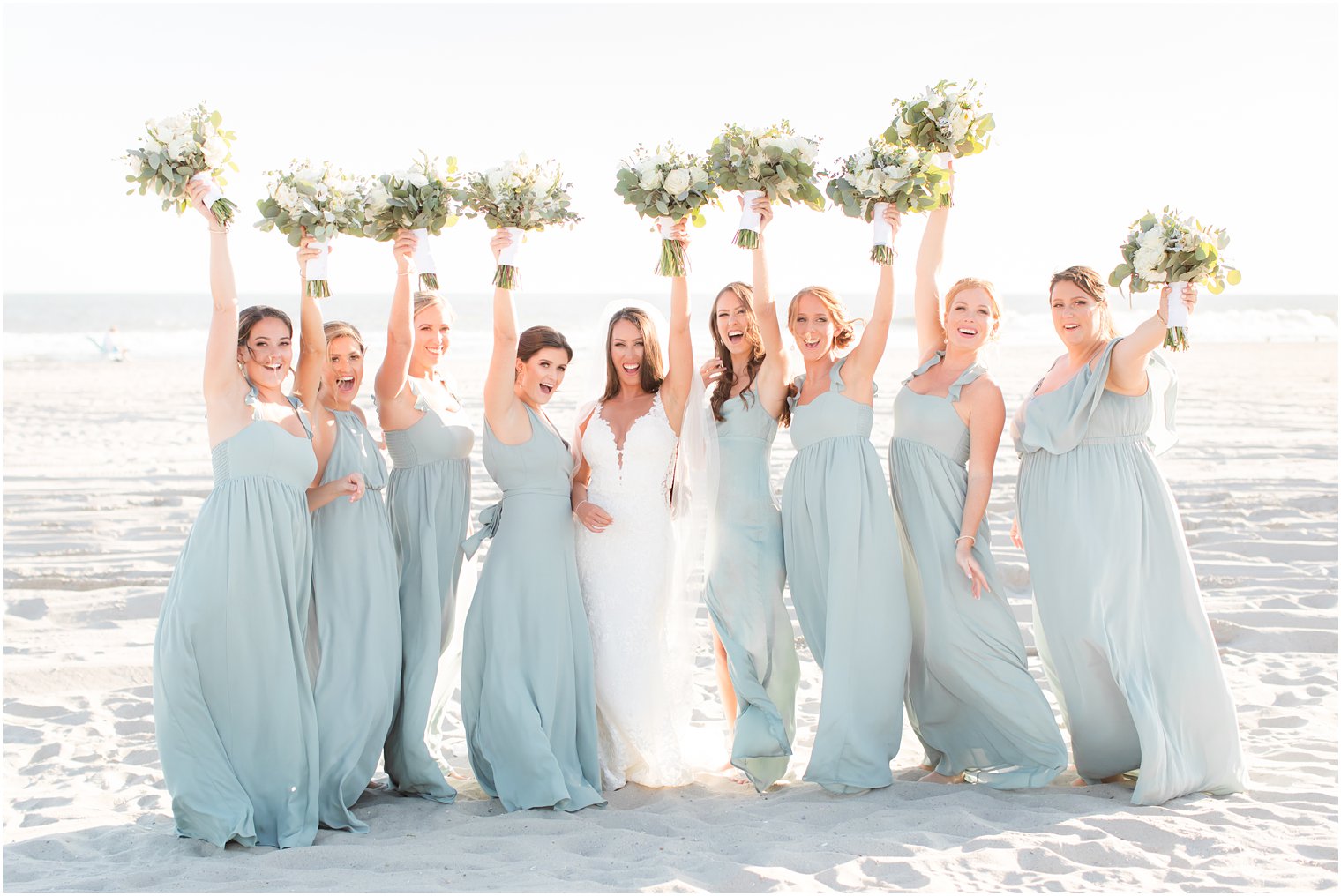 bridesmaids cheer during beach wedding photographed by Idalia Photography