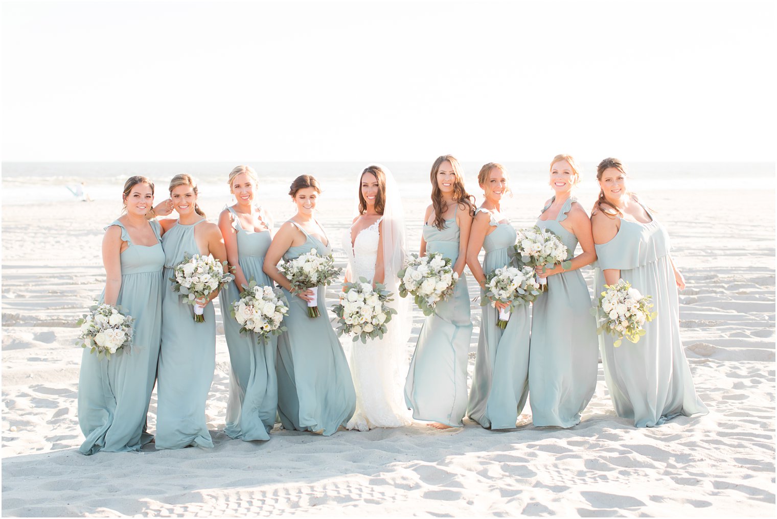 bride and bridesmaids pose on the beach for LBI wedding photos