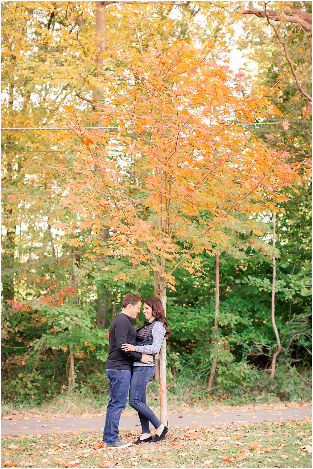 engagement portraits under tree with orange leaves in Watchung Reservation