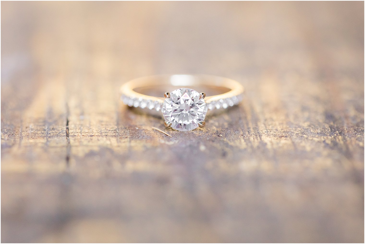 engagement ring rests on wooden plank