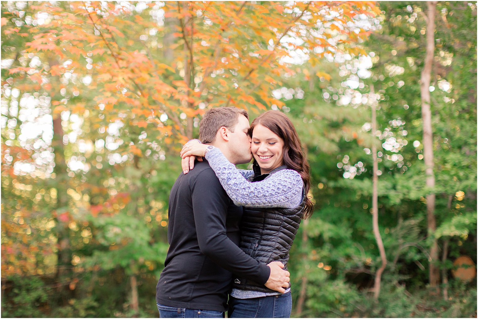 groom kisses bride on cheek during cozy fall engagement session in New Jersey