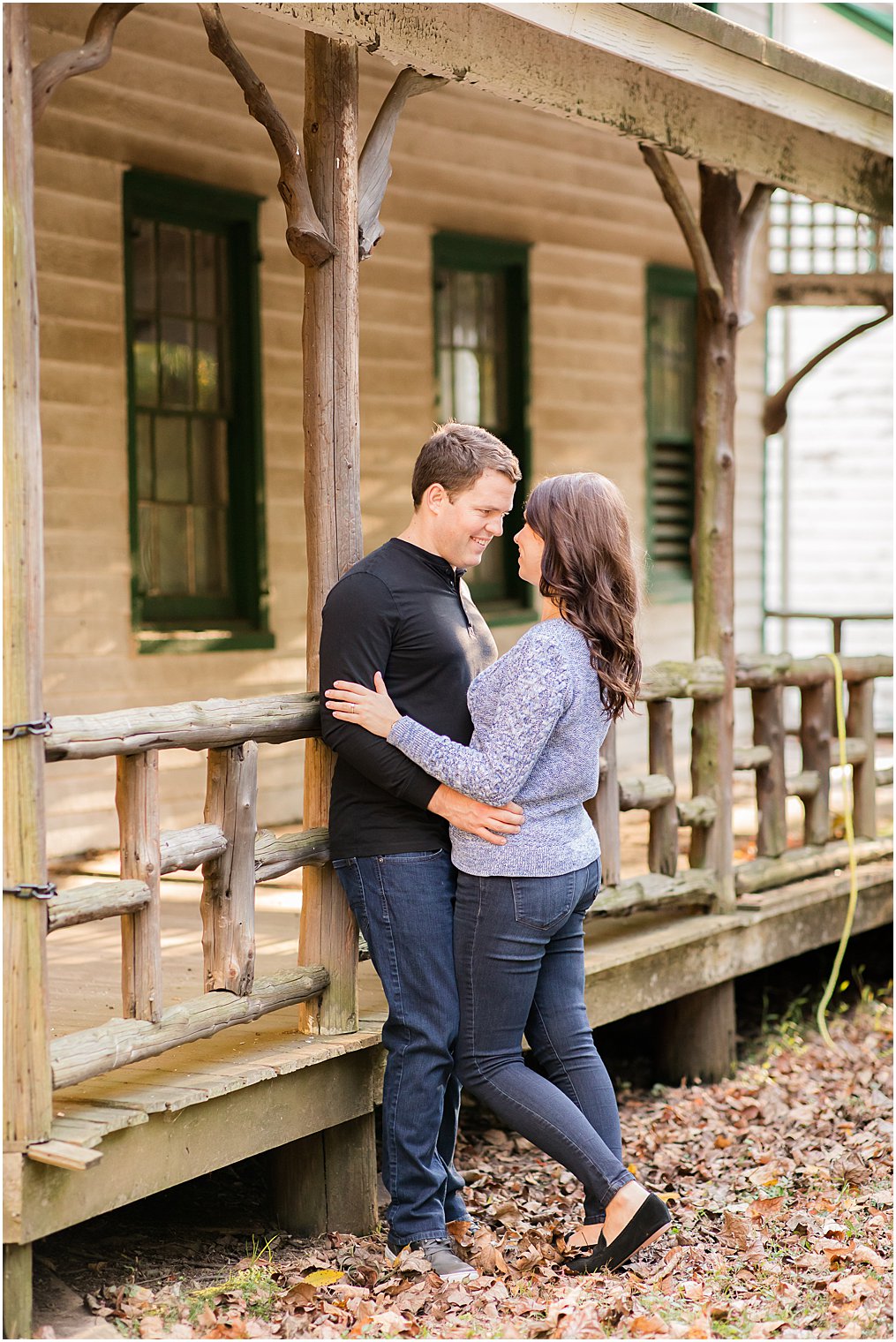 engaged couple poses against cabin on Watchung Reservation