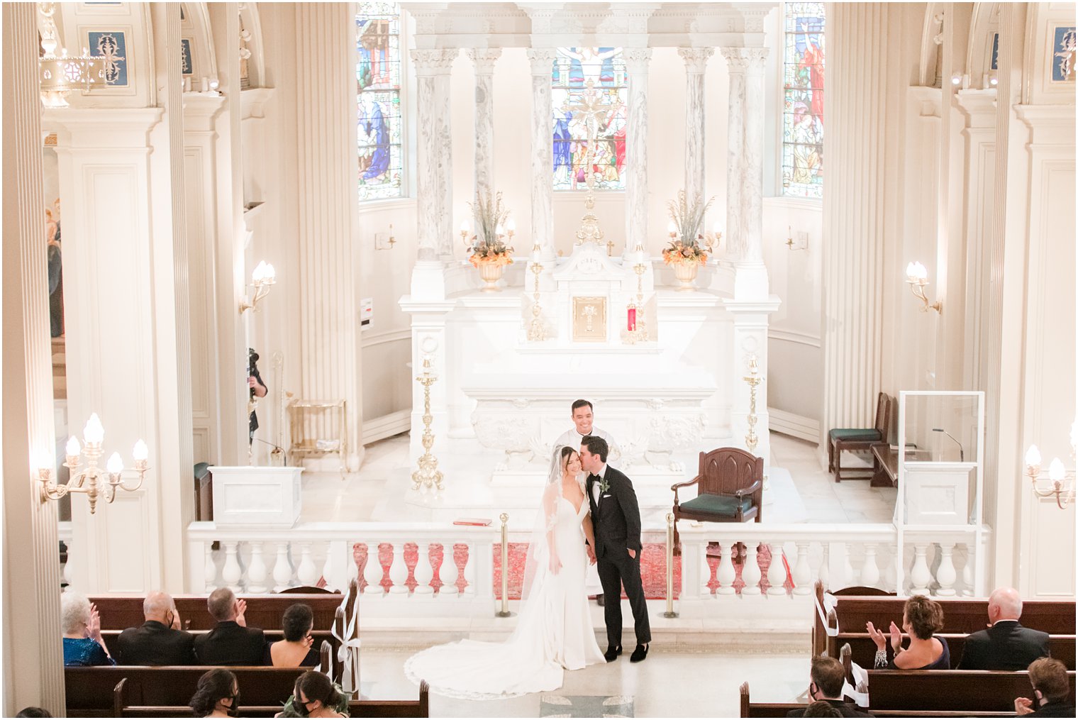 groom kisses bride's cheek during traditional church wedding at St. Catharine's Church in Spring Lake NJ