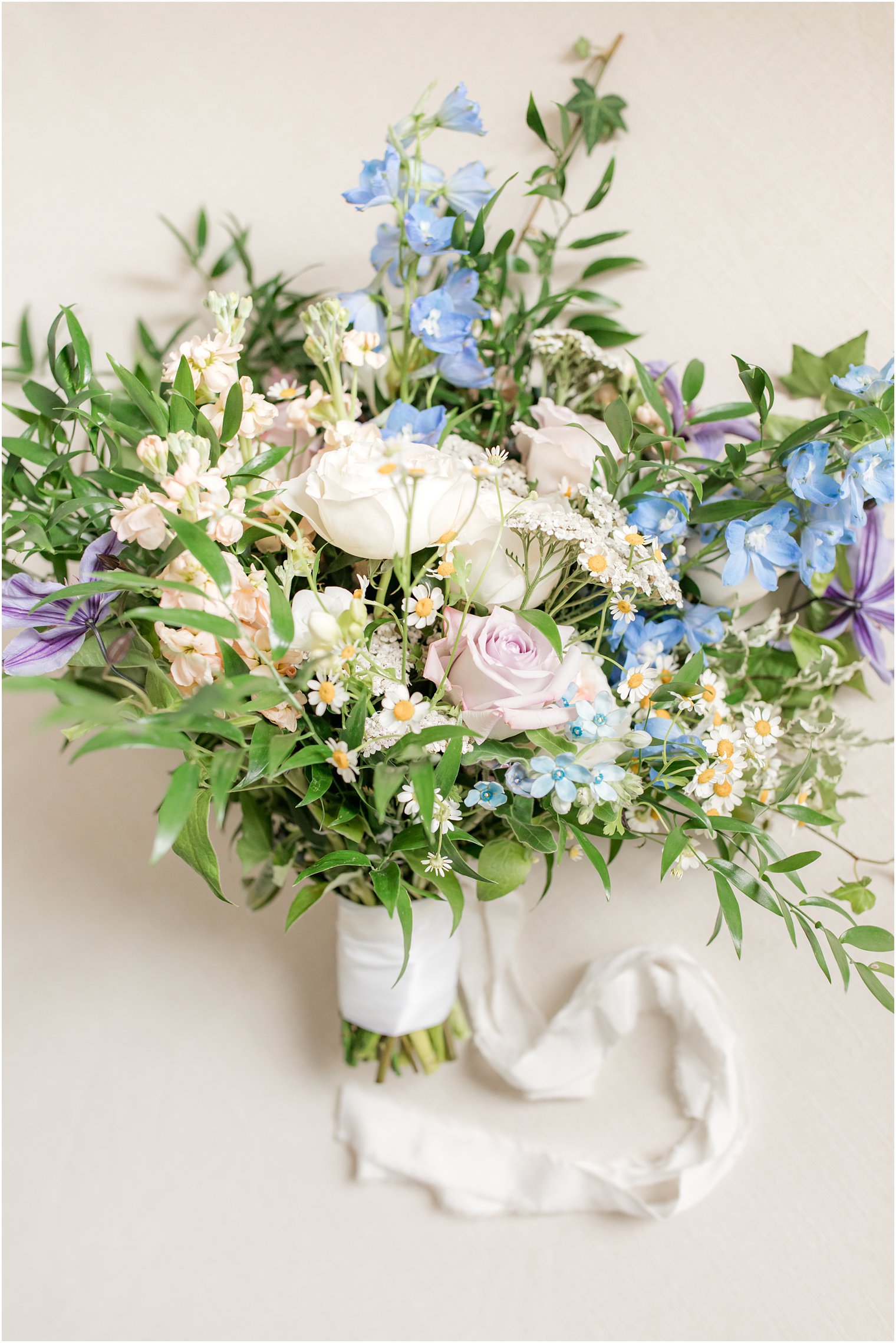 bride's bouquet of white and pink roses and blue wildflowers 