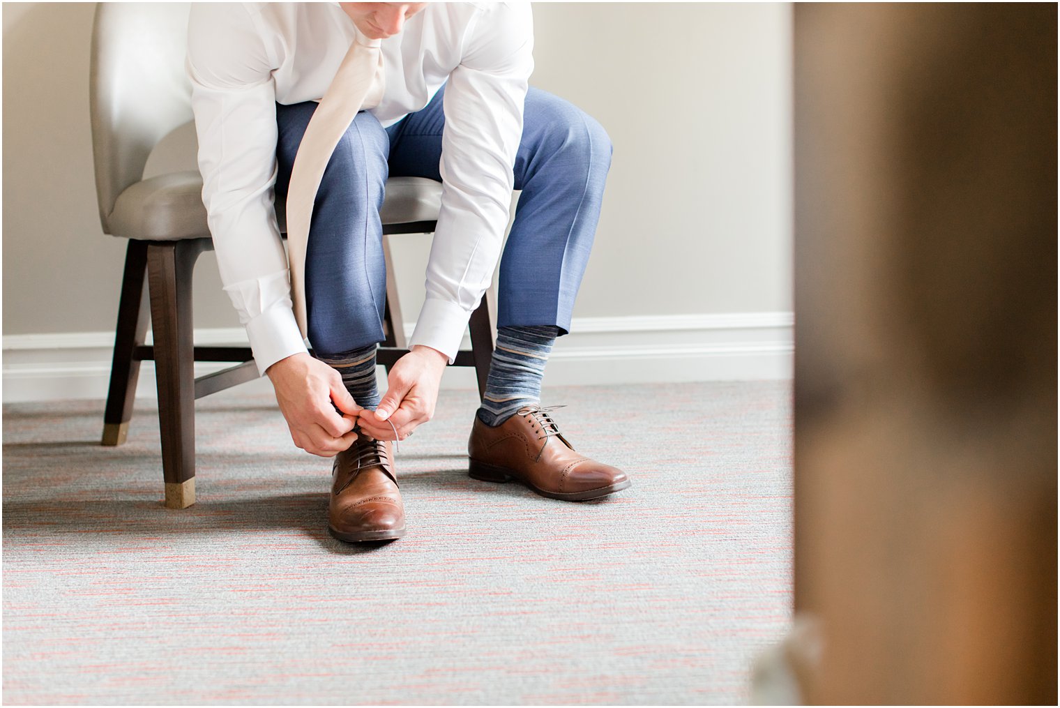 groom ties shoes on NJ wedding day 