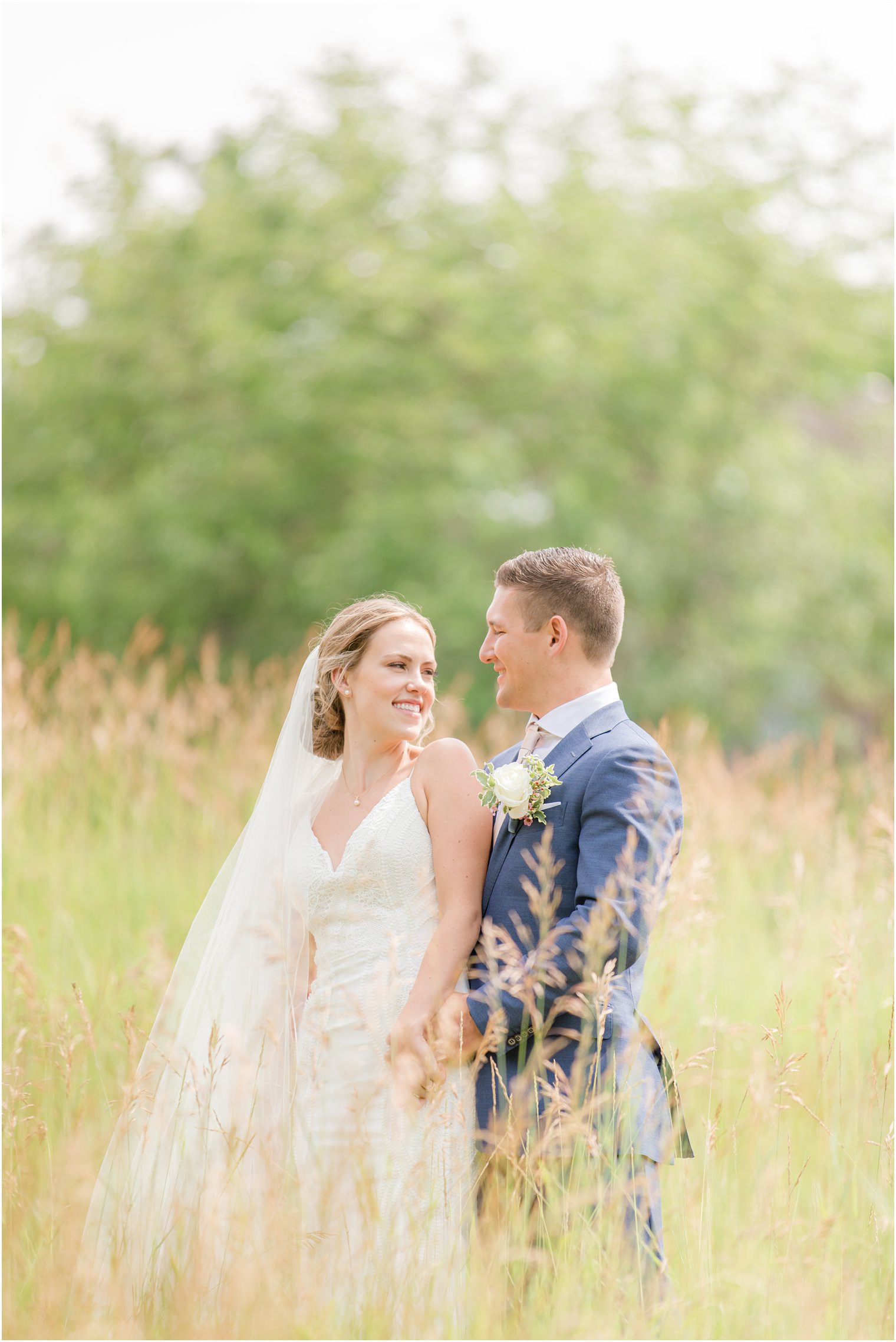 bride and groom stand holding hands in field at Minerals Resort