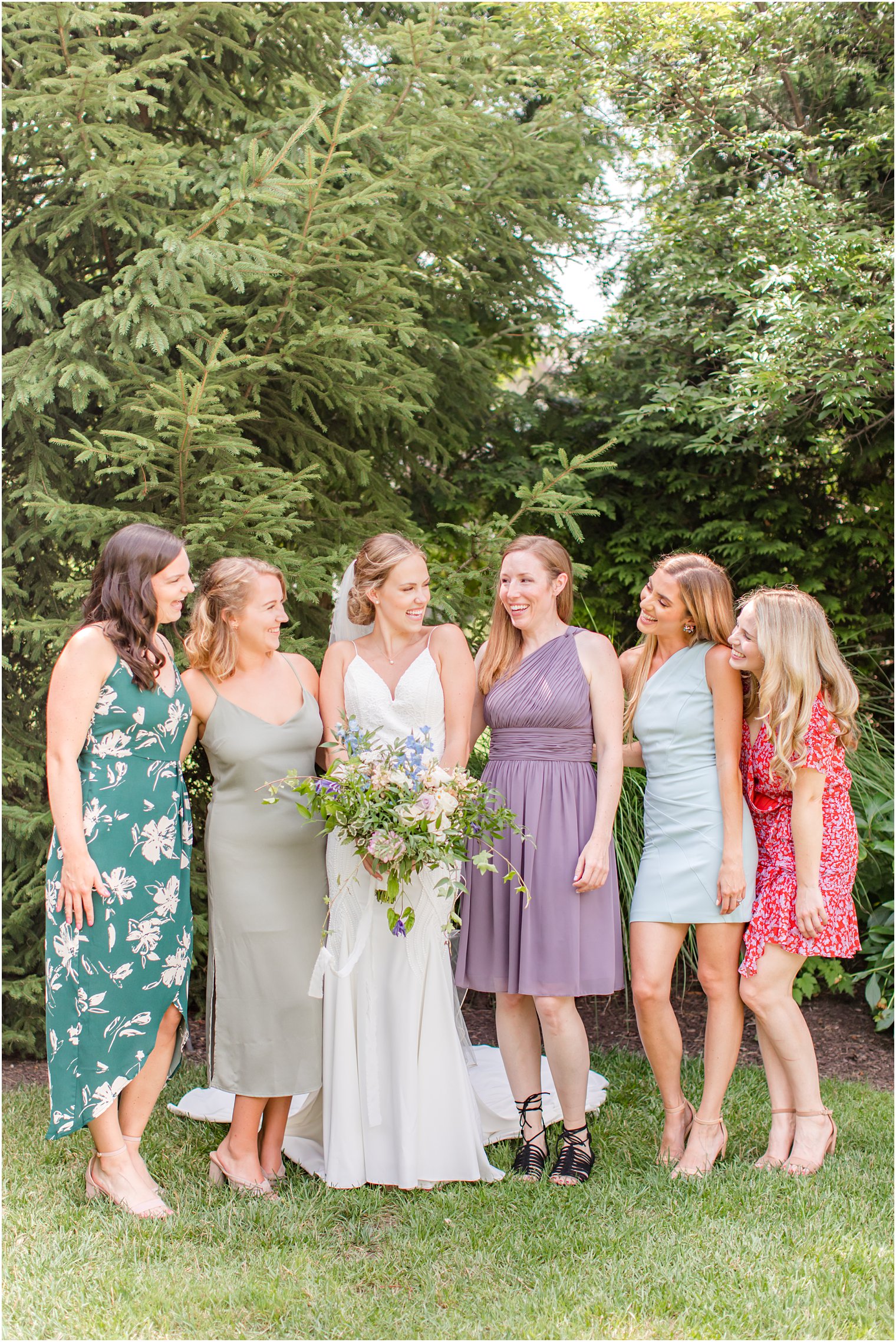 bride poses with bridesmaids during NJ wedding day