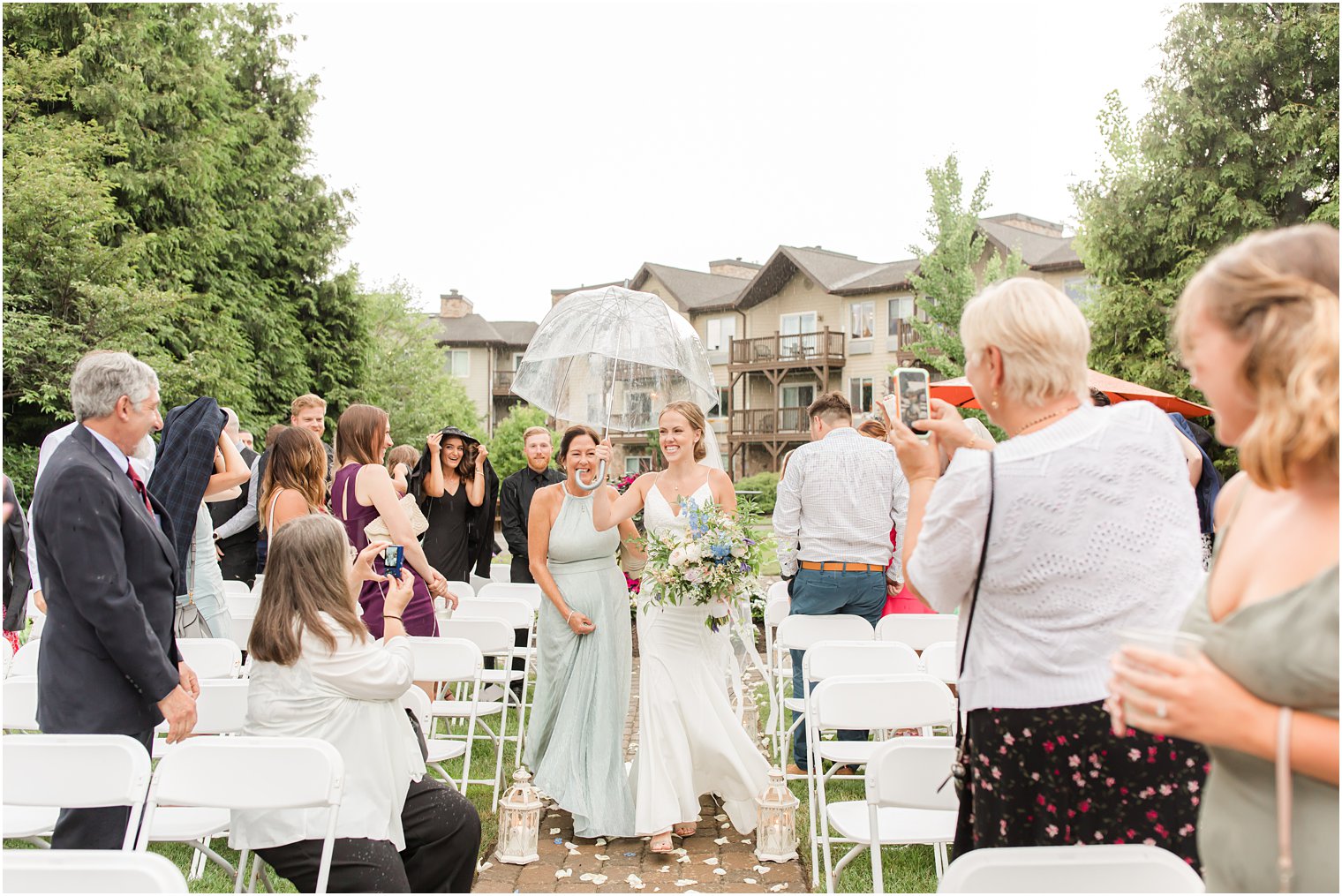 mother of bride walks down aisle with bride during rainy wedding ceremony in Vernon NJ