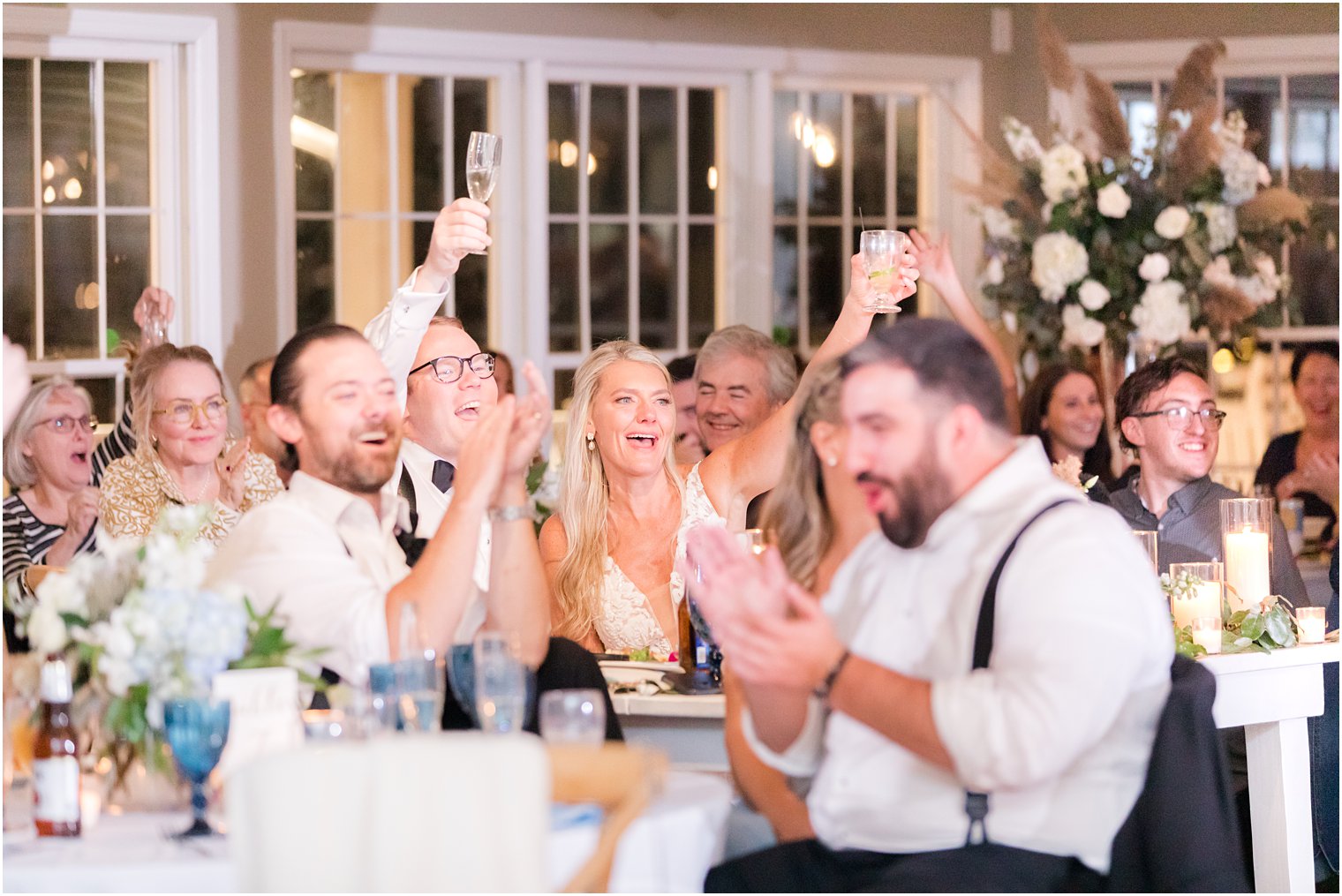 newlyweds raise glasses for toasts during Long Beach NJ wedding reception 