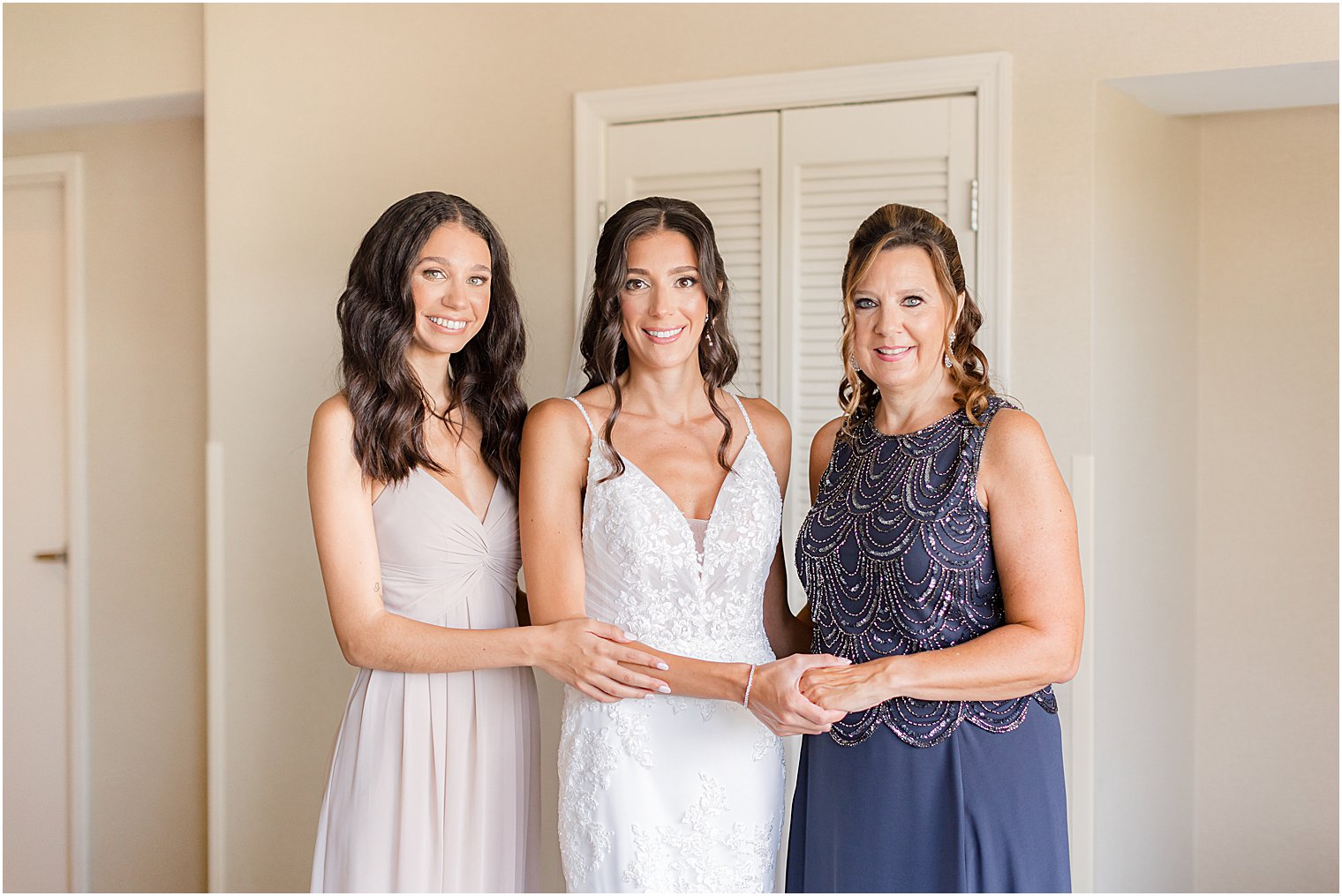 bride and bridesmaid pose with mother during prep at The Mill Lakeside Manor