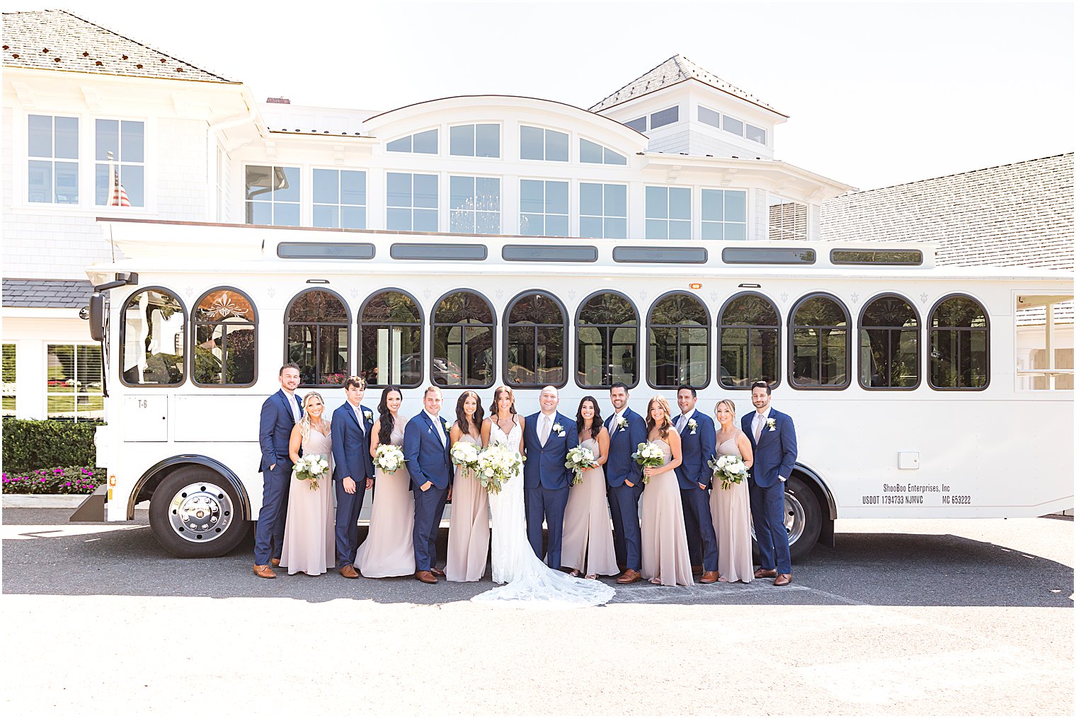 newlyweds stand with wedding party by white trolley at The Mill Lakeside Manor