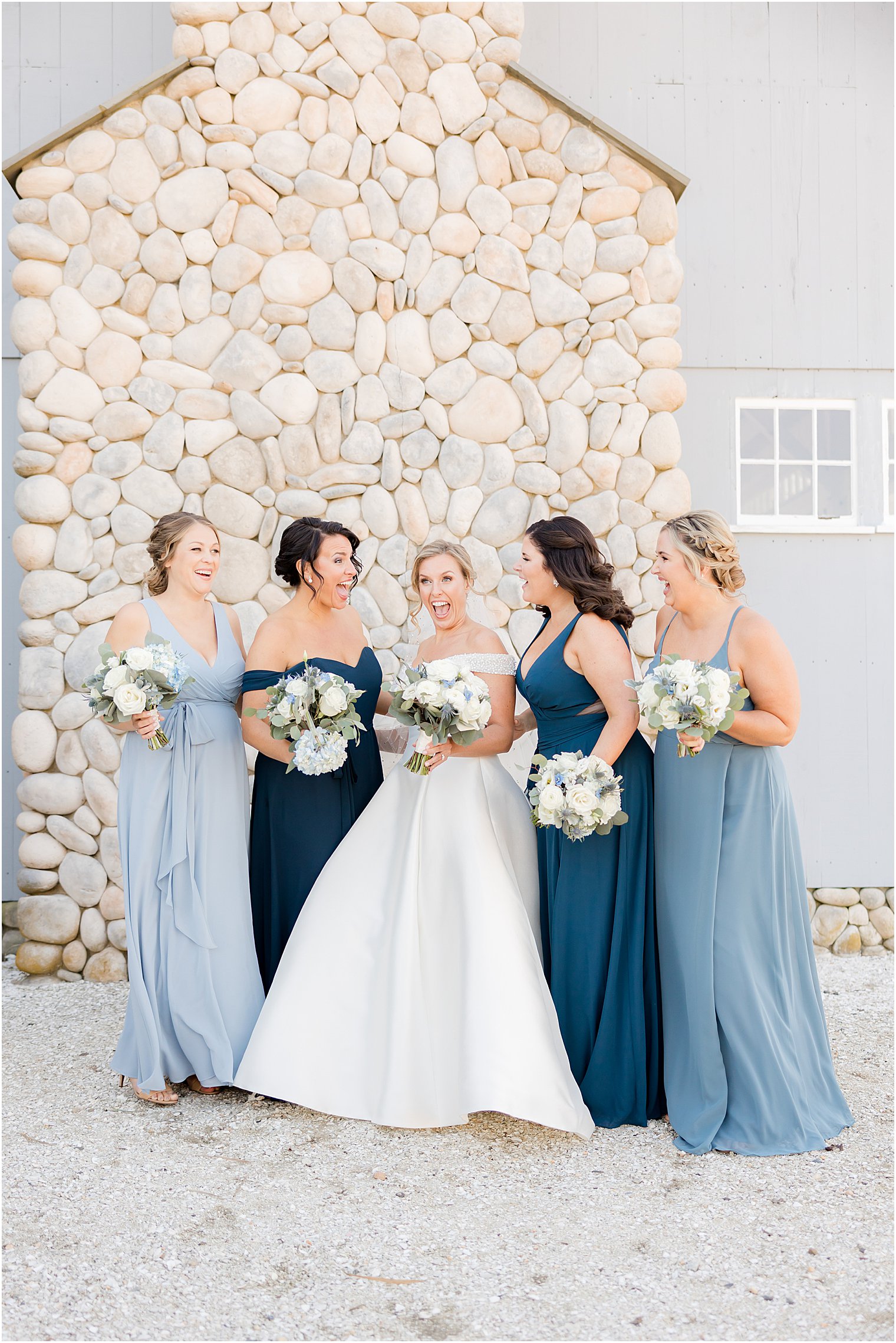 bride laughs with bridesmaids in blue gowns
