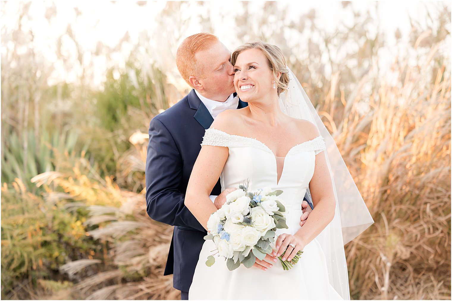 groom hugs bride to him from behind during portraits at Bonnet Island Estate