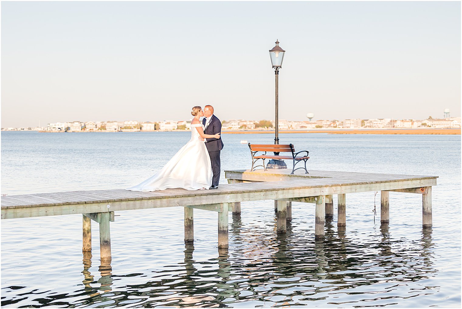 bride and groom hug on dock at Bonnet Island Estate