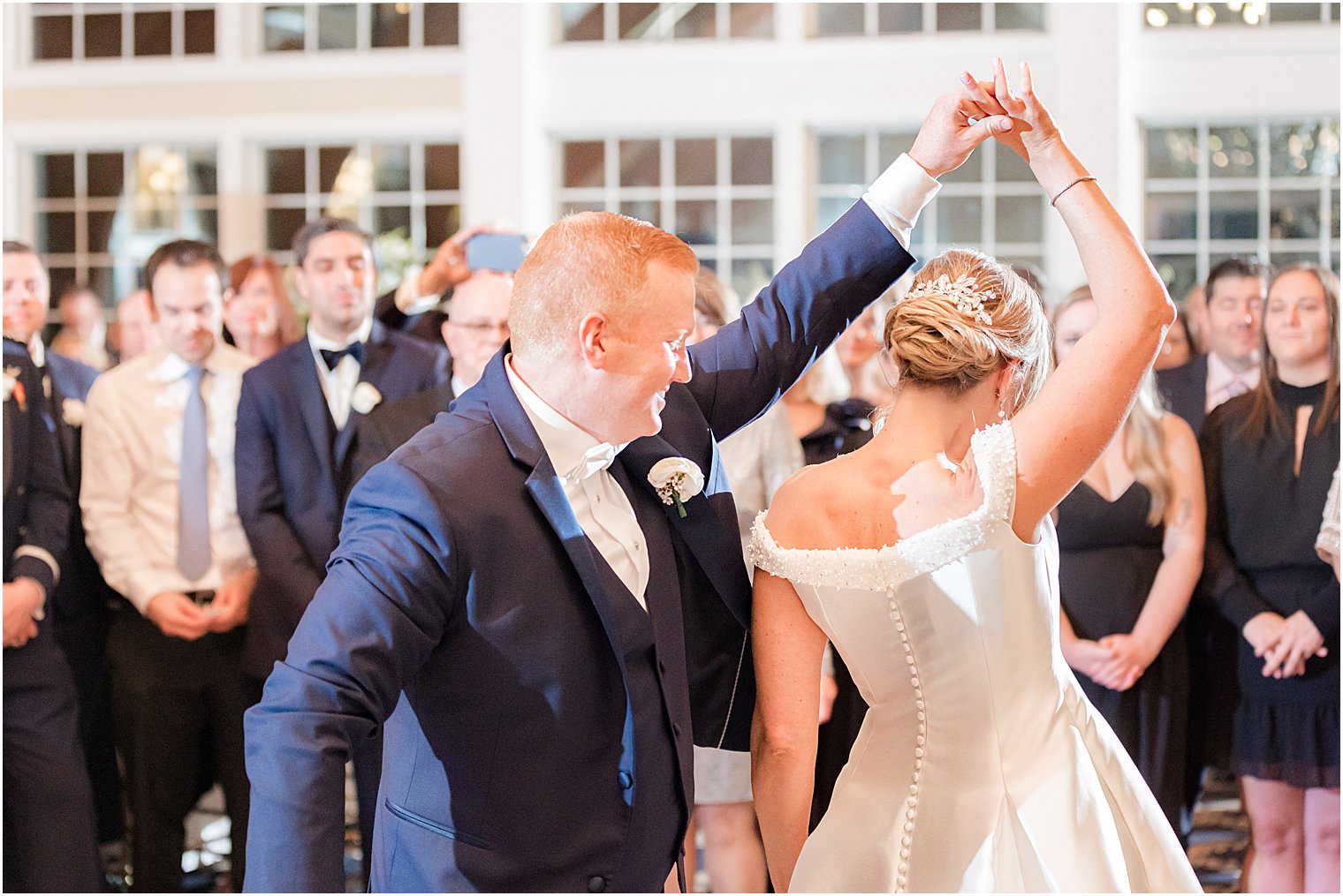 groom twirls bride under his arm during LBI wedding reception