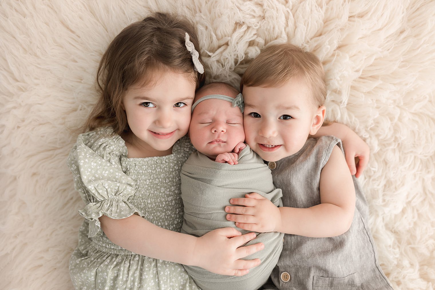 baby girl in her new born session with her siblings 