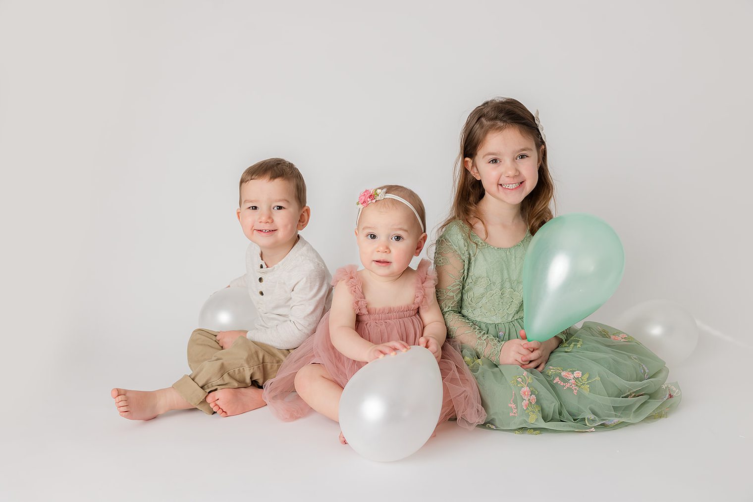 baby girl and her siblings at her one year session