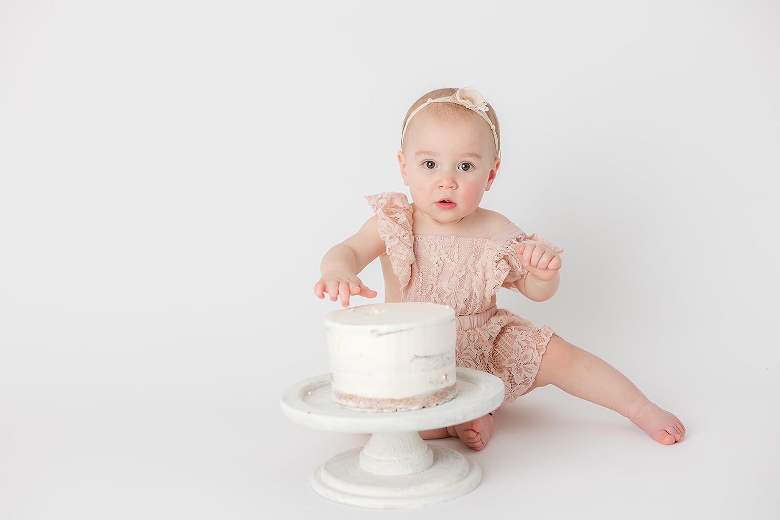 baby girl looking at the camera at her one year session