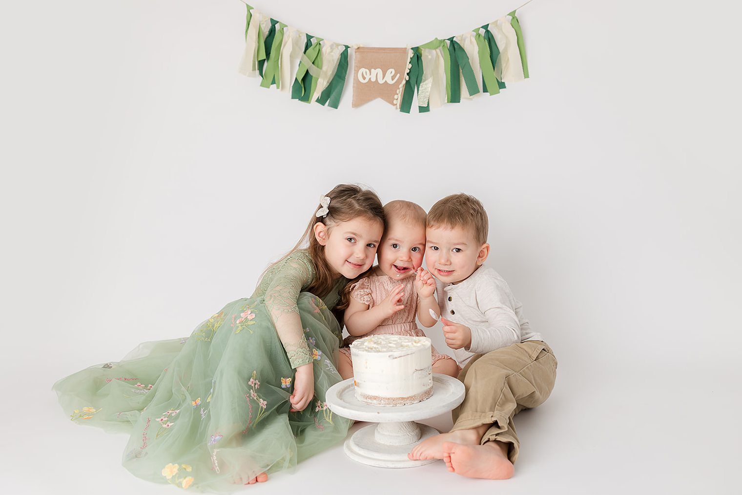 baby girl and siblings enjoying the cake 