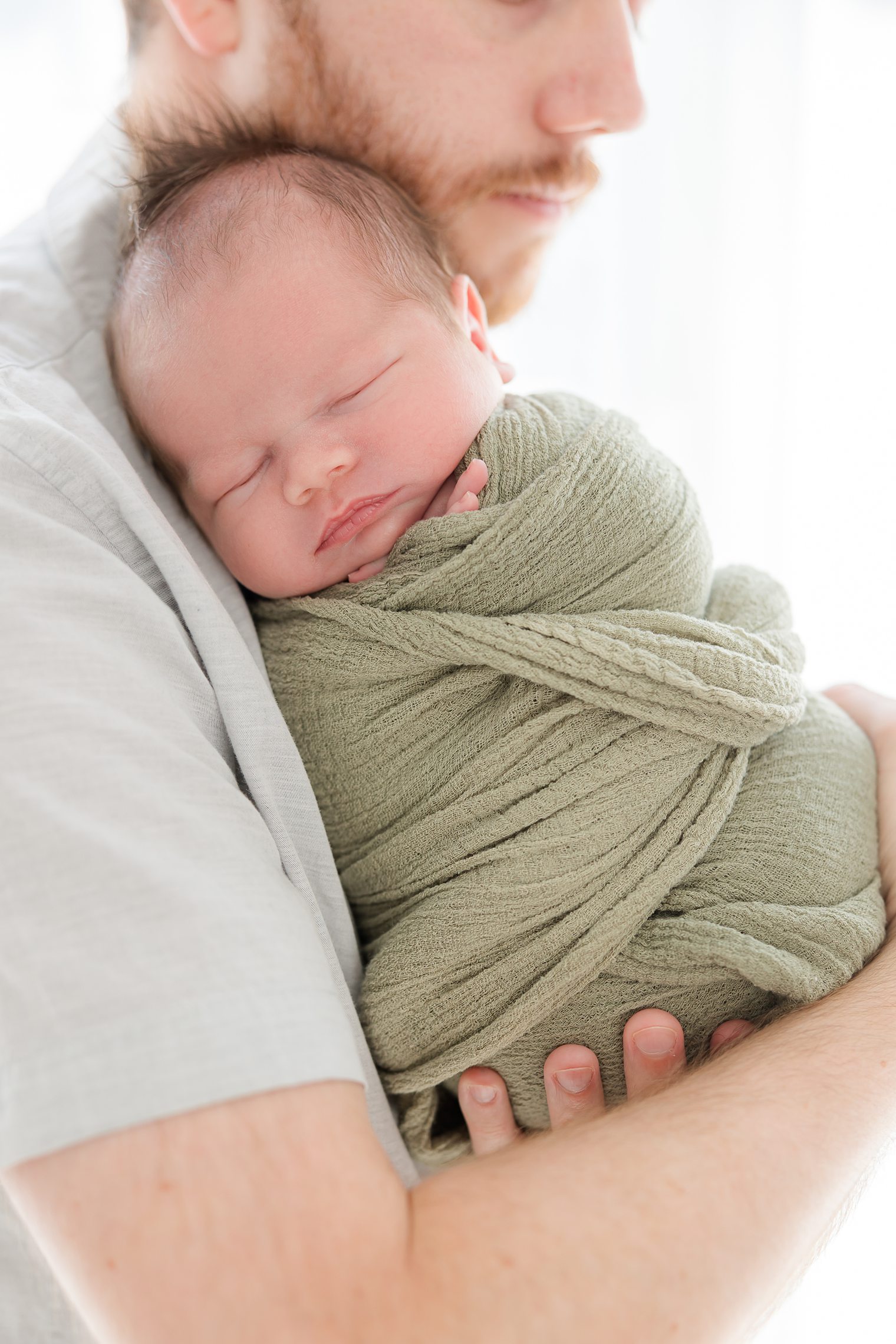 baby boy sleeping in his father arms 