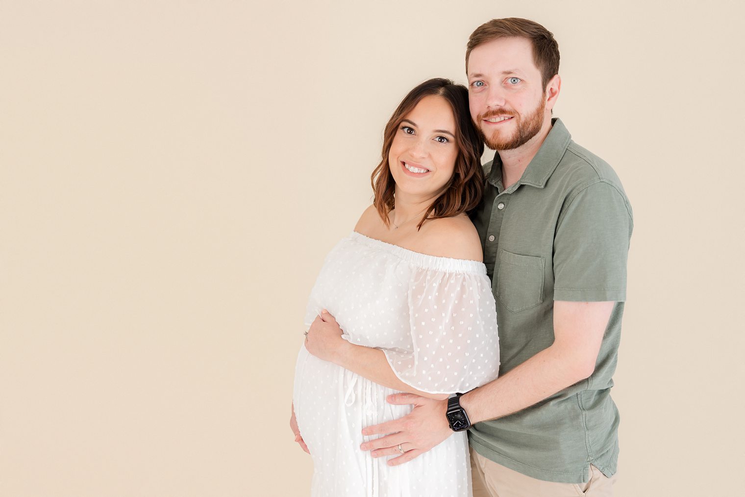 mom and dad posing for their maternity shoot