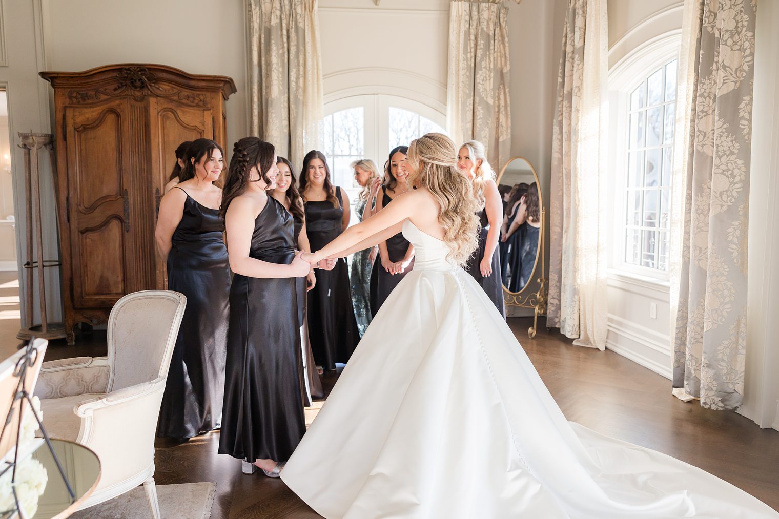 bride showing her dress to her bridesmaids 