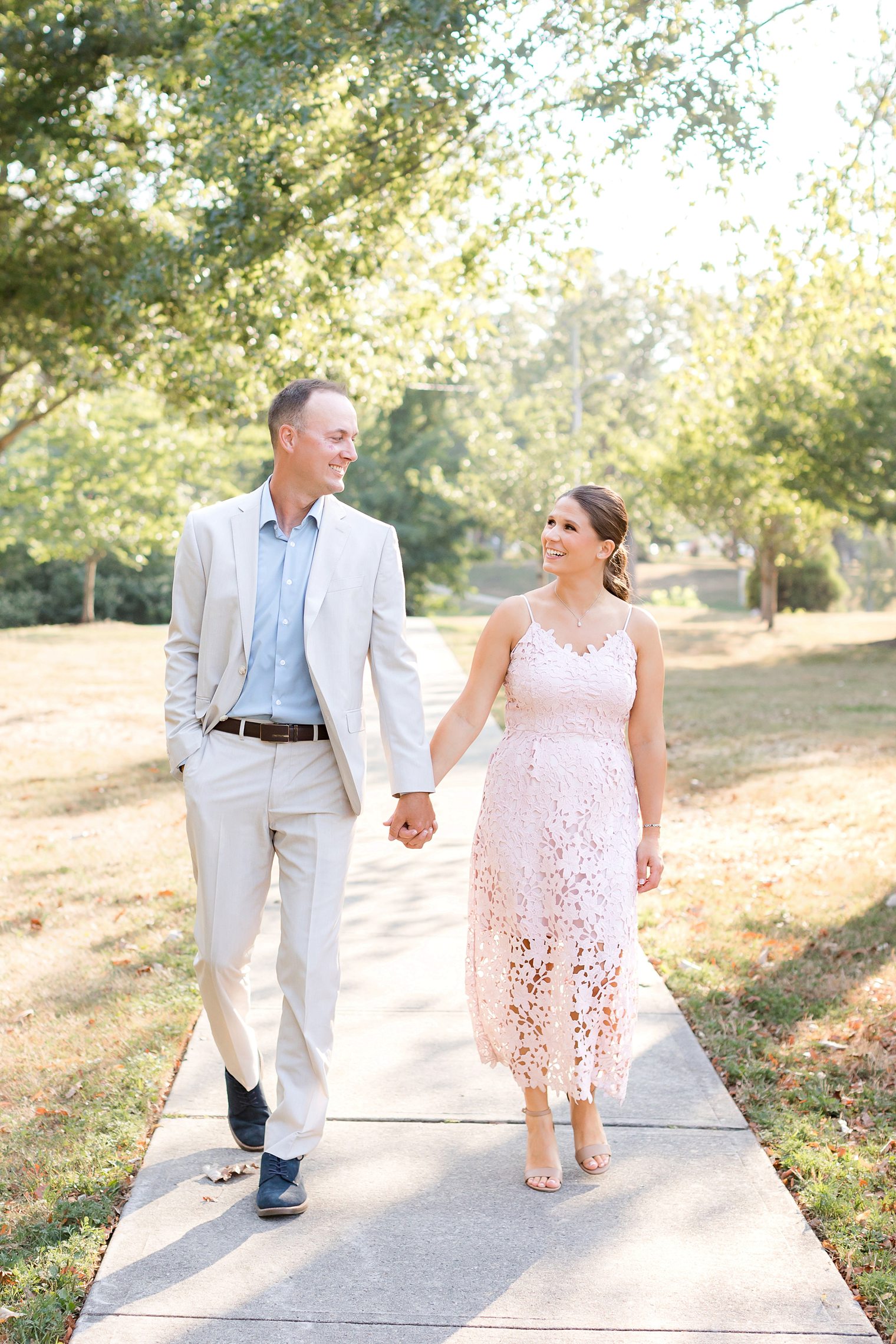 groom and bride holding hands while they walk and look each other at Spring Lake