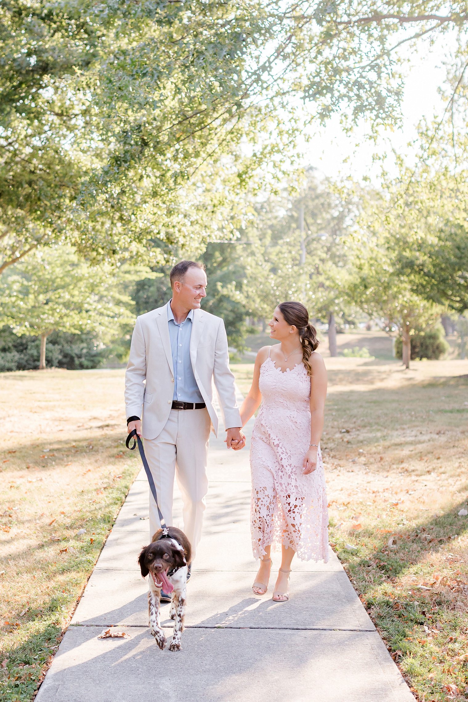 groom and bride walking with their furry friend 