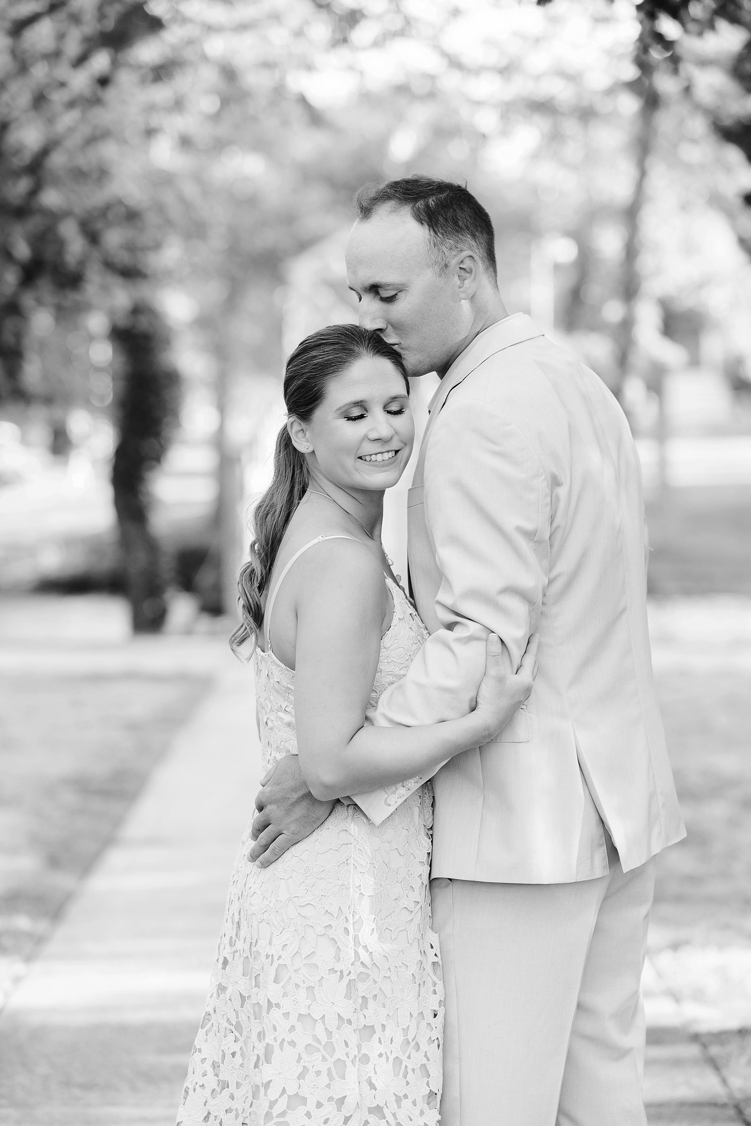 Groom kissing his bride forehead 