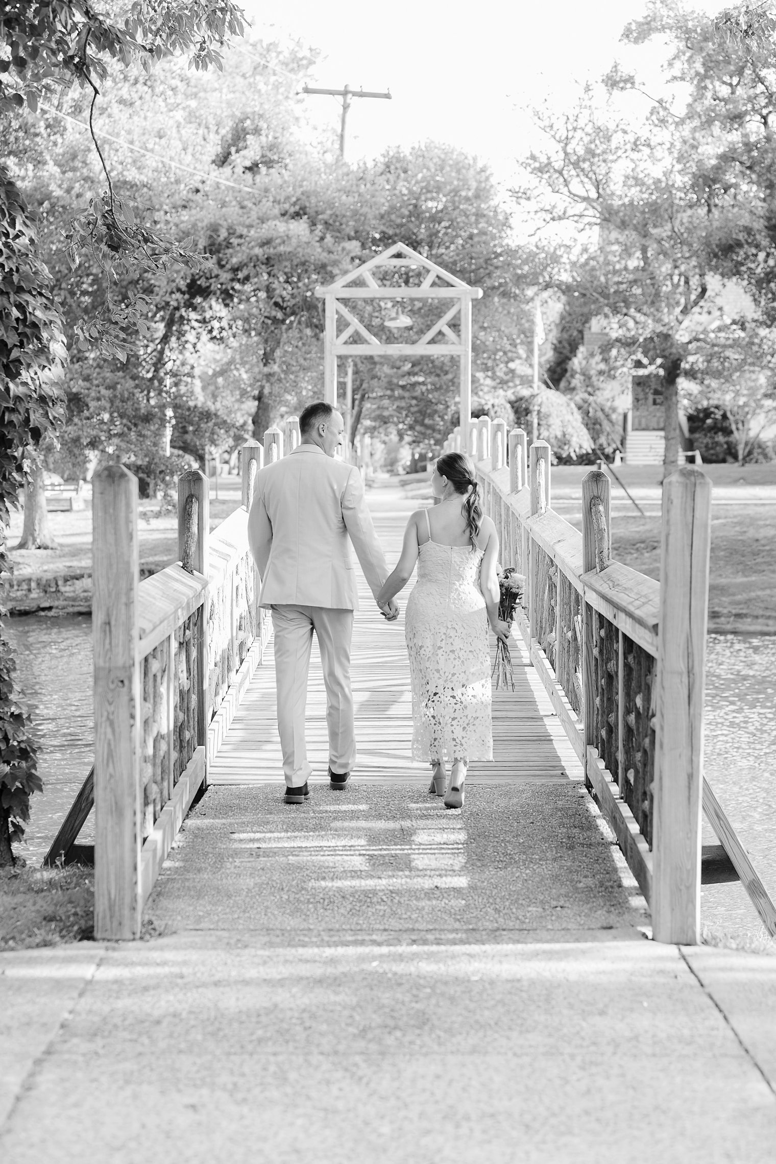 groom and bride walking in the bridge while the holding hands 