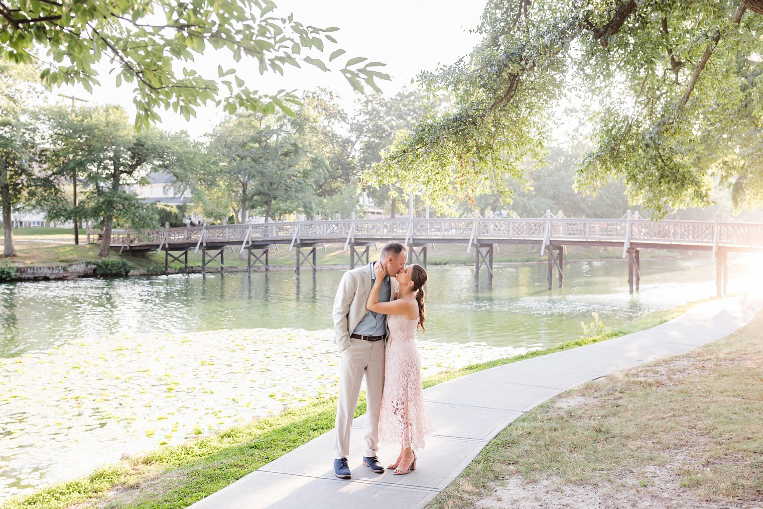 groom and bride sharing a kiss at Spring Lake for their engagement session