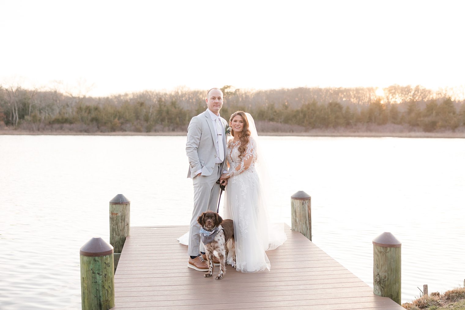 husband and wife enjoying the sunset with their furry friend 