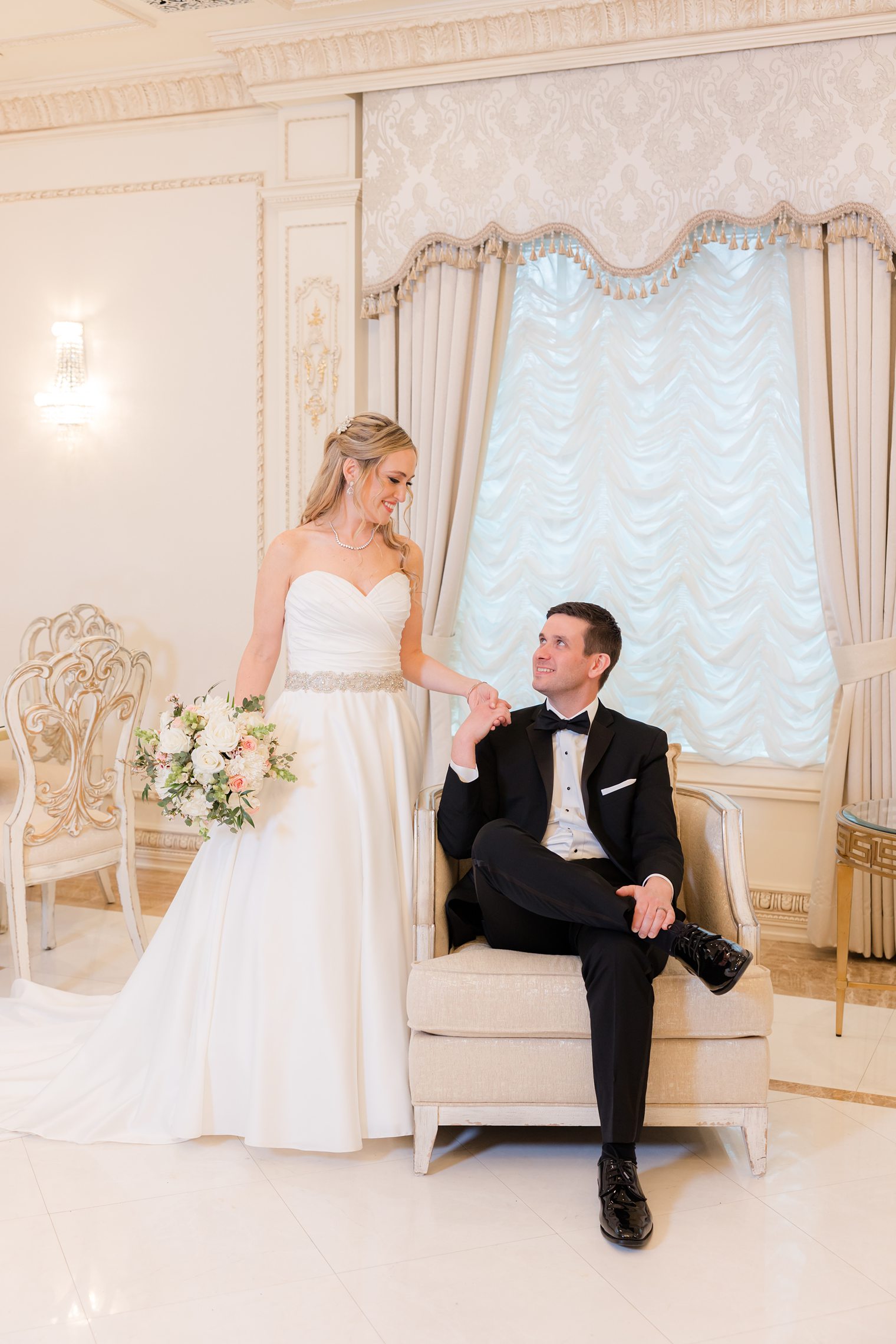 husband sitting on the chair while holding his wife's hand 