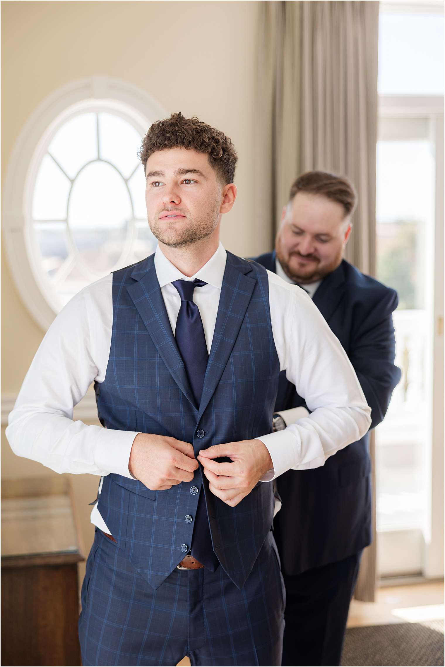 best man helping the groom get dressed