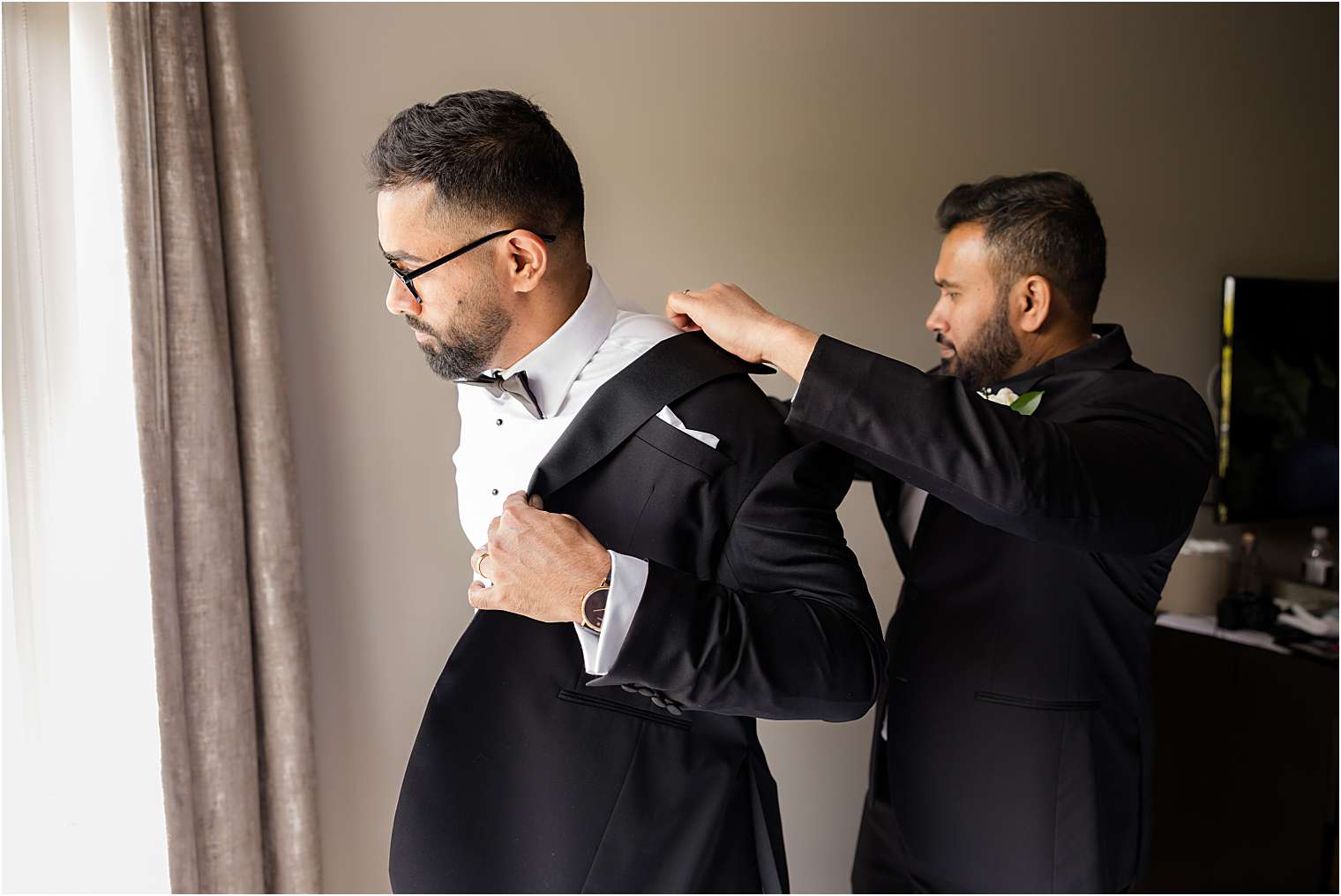 one of the best men helping the groom with final touches