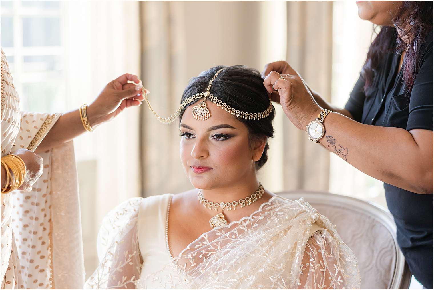 The bride is seated, radiating elegance with her intricate lace attire.