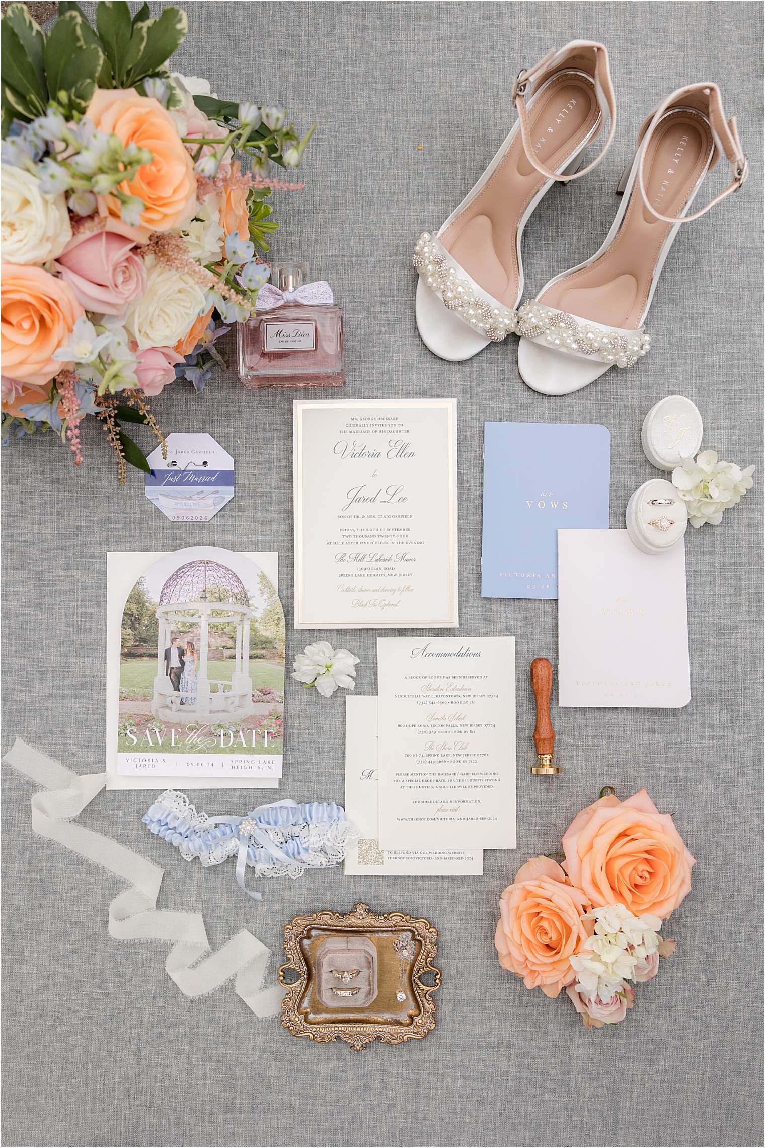 Wedding invitation details. Coral roses, Miss Dior perfume, and a wax seal stamp add elegant touches.