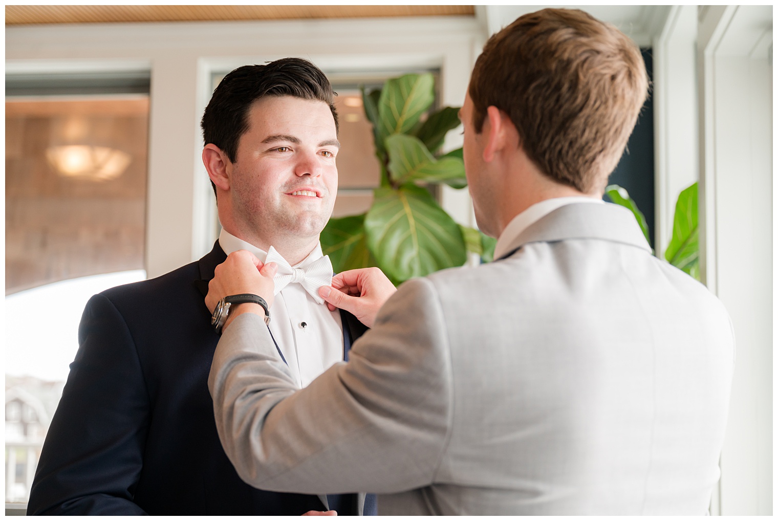 best man helping the groom with final touches