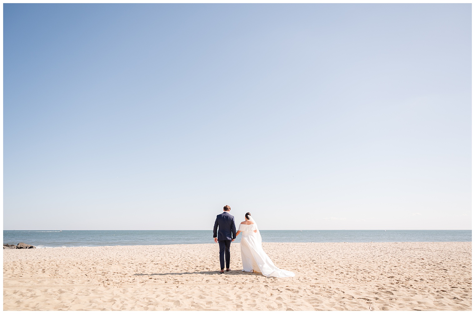 bride and groom walking on the beach