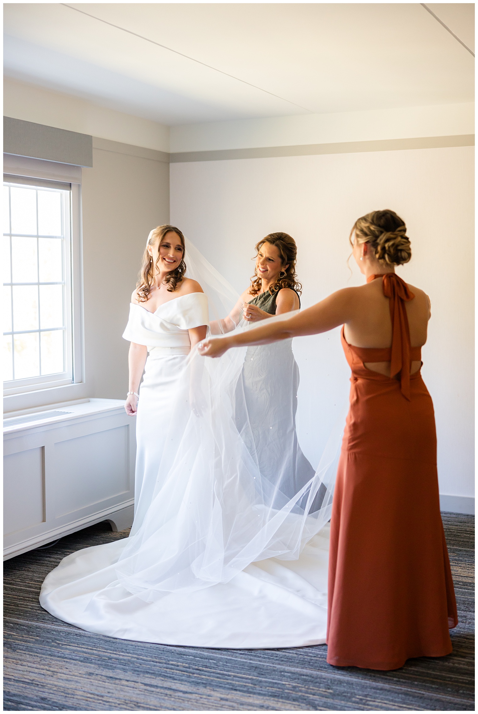 bridesmaids helping bride with final touches